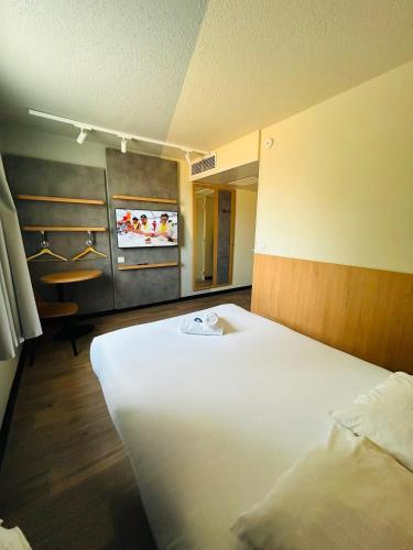 a hotel room with a bed and a tv at Hôtel Inn Design Montluçon in Montluçon