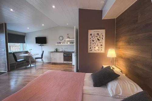 a bedroom with a bed and a kitchen with a table at Thoristun Apartments in Selfoss