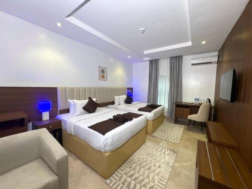 a hotel room with a large bed and a couch at Movela Hotels in Warri