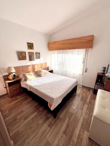 a bedroom with a bed and a wooden floor at Bed and Breakfast Omas Huisje in Ciudad de la Costa