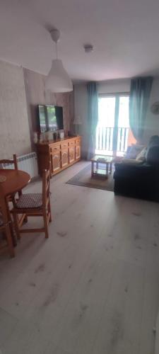 a living room with a table and a couch at Carlina Canfranc in Canfranc-Estación