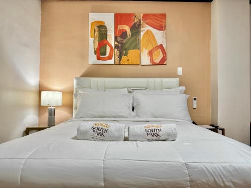 ein Schlafzimmer mit einem weißen Bett, auf dem Handtücher liegen in der Unterkunft SouthPark Hotel Naga in Concepcion