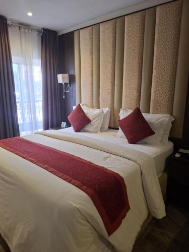 a hotel room with two beds with red and white pillows at Danville Hotel Ltd in Freetown