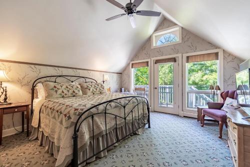 a bedroom with a bed and a balcony at Sylvan Inn Bed & Breakfast in Glen Arbor