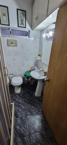 a bathroom with a sink and a toilet and a mirror at Bed and Breakfast Omas Huisje in Ciudad de la Costa