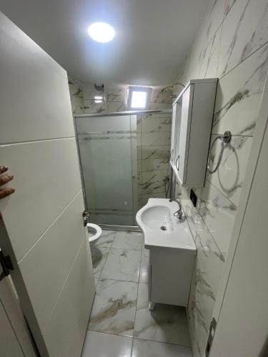 a white bathroom with a sink and a shower at TURKERHOMe in Ordu