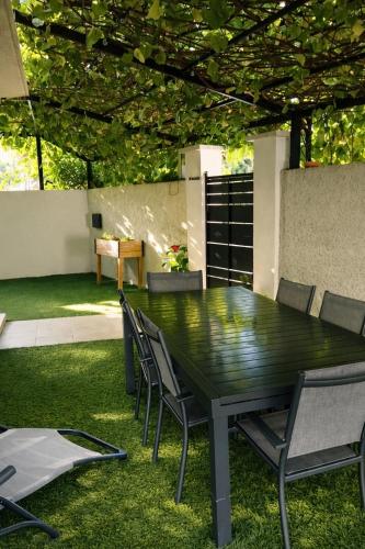 a green table and chairs in a yard at Villa J et V in Bédarrides