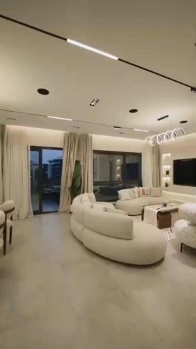 a large living room with white furniture and a mirror at مدينتي برافادو in Madinaty