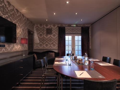 a restaurant with a large wooden table and chairs at Malmaison Edinburgh in Edinburgh
