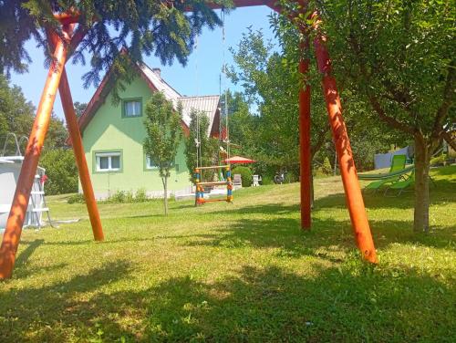 a park with a playground with orange poles in the grass at Vila Jezerce Zlatibor Zbojštica in Užice