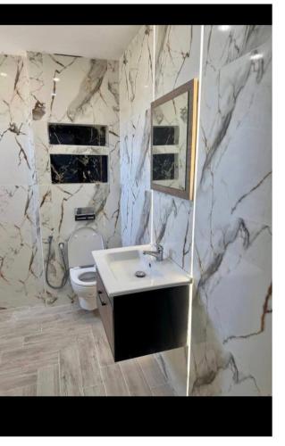 a bathroom with a sink and a marble wall at Kelibia in Kelibia
