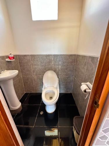 a bathroom with a toilet and a sink at Hospedaje Vista Ausangate in Labramarca