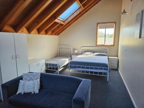 a living room with two beds and a couch at Billungar Unit 2 at Hat Head - 1 Creek Street in Hat Head