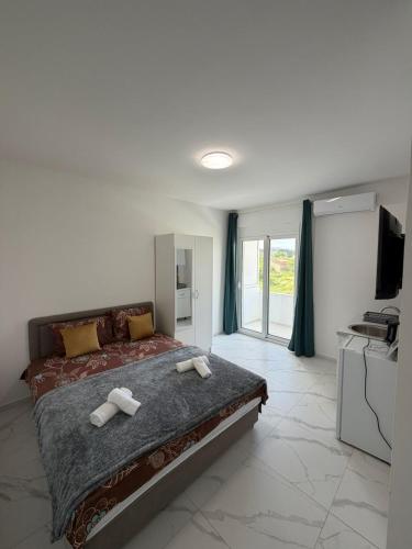 a bedroom with a large bed with two towels on it at Apartments Gzim Peja in Ulcinj