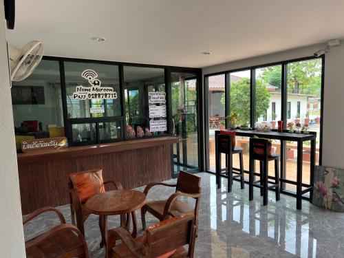 a restaurant with chairs and tables and a bar at Ma Room Place Sukhothai Resort in Sukhothai
