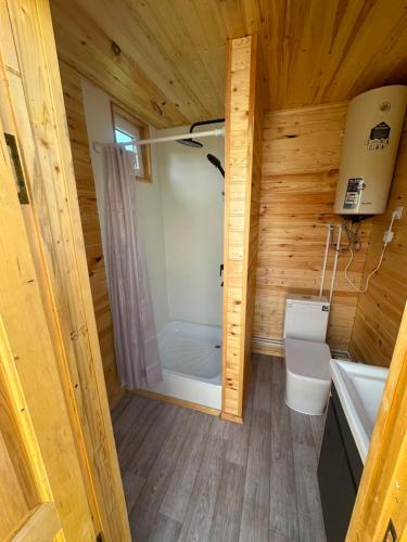 a small bathroom with a shower and a toilet at Nomads Home in Tong