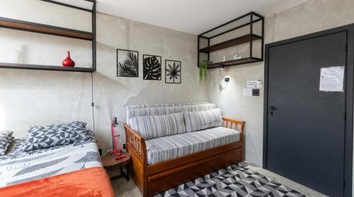 a bedroom with a bed and a chair in it at FLAT PALLADIUM - de frente in São Vicente