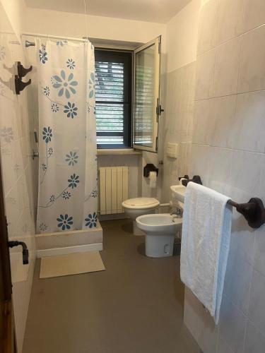 a bathroom with a toilet and a shower curtain at Agriturismo Monte Sacro in Mattinata