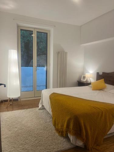a white bedroom with a large bed with a yellow blanket at Agriturismo Monte Sacro in Mattinata