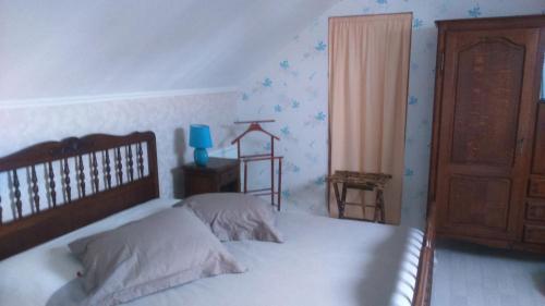 ブレレにあるL'écume du Cherのベッドルーム1室(大型ベッド1台、木製ヘッドボード付)