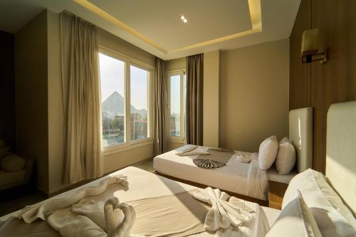 a hotel room with two beds and a window at Kemet Pyramids View Hotel in Cairo