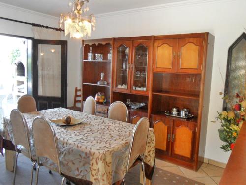 a dining room with a table and chairs and a chandelier at Vivenda Silvestre in Albufeira