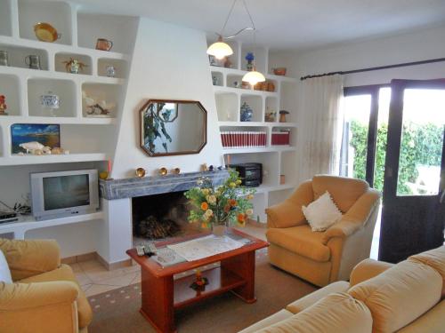 a living room with two chairs and a fireplace at Vivenda Silvestre in Albufeira