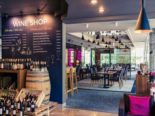 a wine shop with tables and chairs and wine bottles at Mercure Lublin Centrum in Lublin