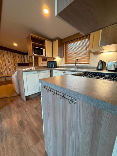 a large kitchen with a counter top in a room at Sandytoes and Seaside smiles in Wyke Regis