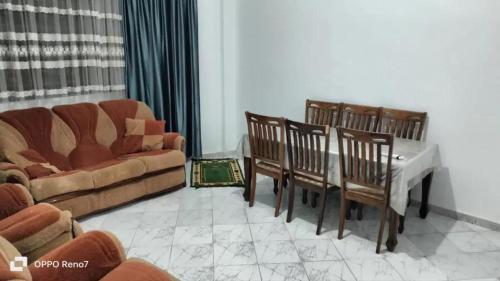 a living room with a couch and a table and chairs at مفروشة السعادة in Tlemcen