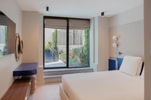 a bedroom with a bed and a large window at Hotel Leev Miromesnil & Spa in Paris
