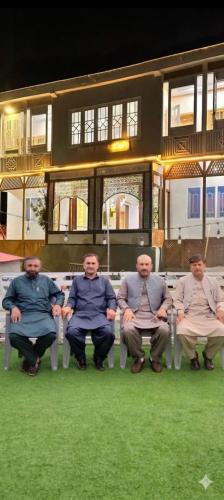a group of men sitting in chairs on the grass at Turgil Green Resort in Nomal