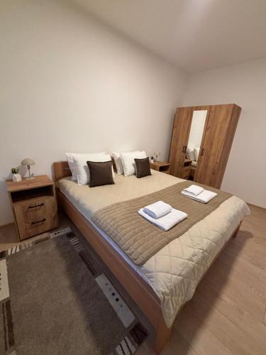 a bedroom with a bed with two towels on it at The Central Passage in Gornji Milanovac