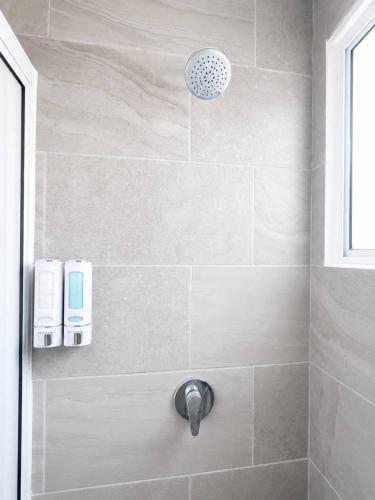 a bathroom with a shower with a shower head at Nice AptPoolBeach ClubParkingGymACBarraVieja in Barra Vieja