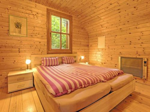 a bedroom with a bed in a wooden cabin at Karawankenpanorama S in Liebenfels