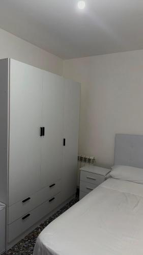 ein weißes Schlafzimmer mit Bett und weißen Schränken in der Unterkunft Hostal Parada in Viladecáns