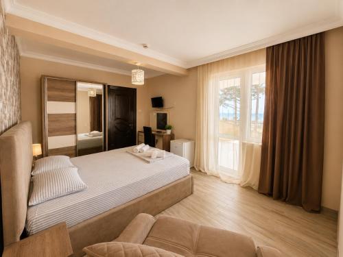 a bedroom with a bed and a large window at Megobroba Hotel in Kobuleti