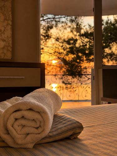 a towel sitting on top of a bed with a window at Megobroba Hotel in Kobuleti