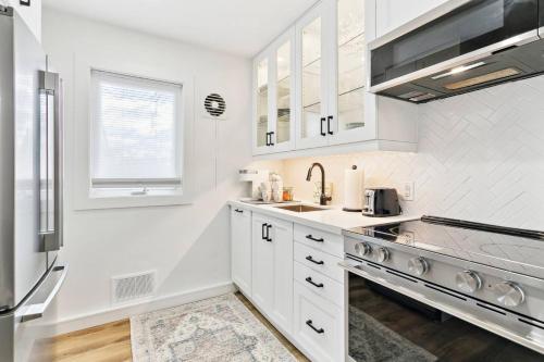 a kitchen with white cabinets and a sink at Modern 3BR Home, Minutes to Lake & Port Credit in Mississauga