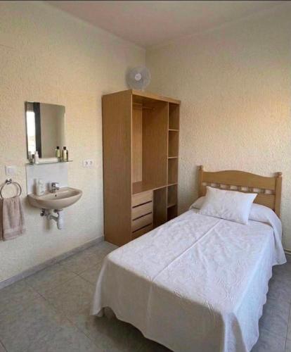 a bedroom with a bed and a sink at Los Hermanos in Viladecáns