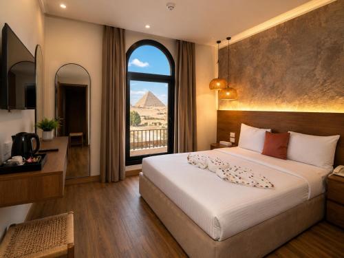 a bedroom with a bed and a view of the pyramids at Le Pacha Pyramids Hotel in Cairo