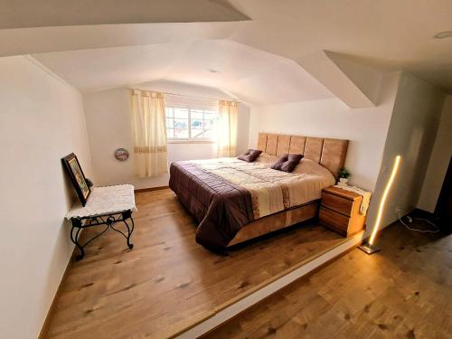 a bedroom with a bed and a chair and a window at Private Pool House Minutes from the Beach in Charneca