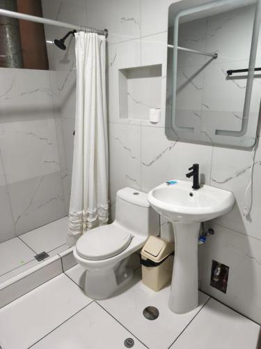 ein weißes Badezimmer mit Toilette und Waschbecken in der Unterkunft Hostal Yaravi in Chivay