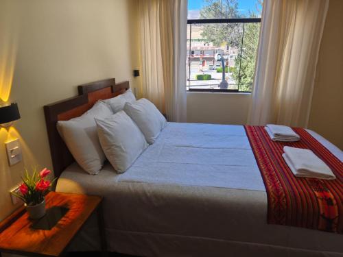 ein Schlafzimmer mit einem großen Bett und einem Fenster in der Unterkunft Hostal Yaravi in Chivay