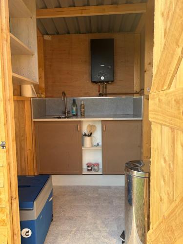 a kitchen with a sink and a tv in a cabin at Looe Valley Camping in Saint Keyne