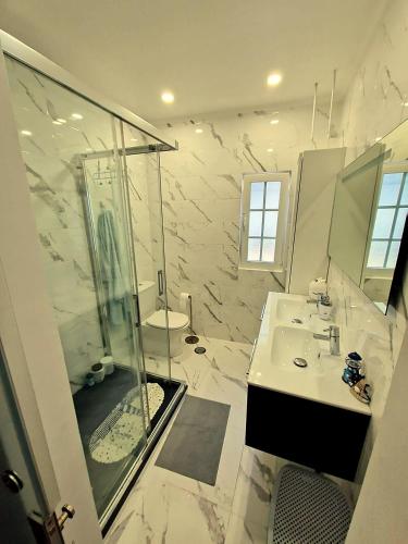 a white bathroom with a shower and a sink at Private Pool House Minutes from the Beach in Charneca