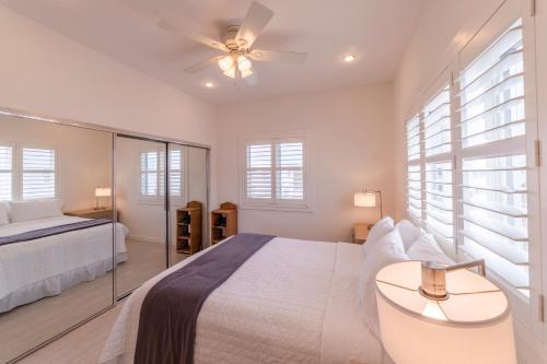a white bedroom with a bed and a ceiling fan at The Hermitage at Napeague in Amagansett