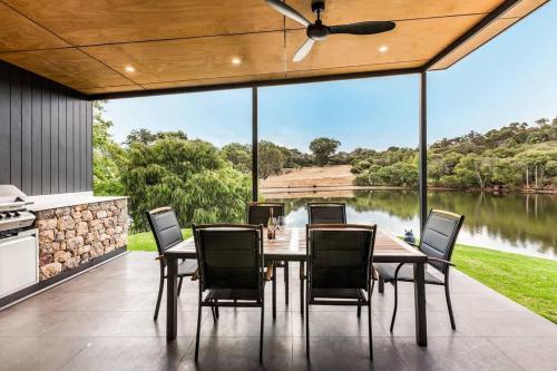a dining room with a view of a lake at Artisan Gunyulgup - Luxe Lakeside Wellness Hideaway in Yallingup