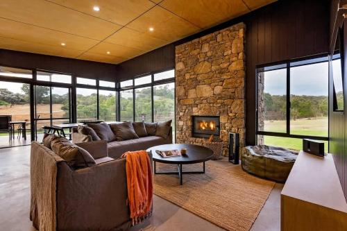 a living room with a couch and a fireplace at Artisan Koorabin - Lakeside Luxe Retreat next to Spa in Yallingup