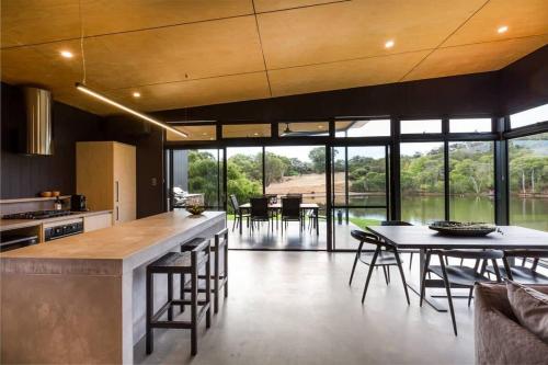 a large kitchen with a table and some chairs at Artisan Koorabin - Lakeside Luxe Retreat next to Spa in Yallingup